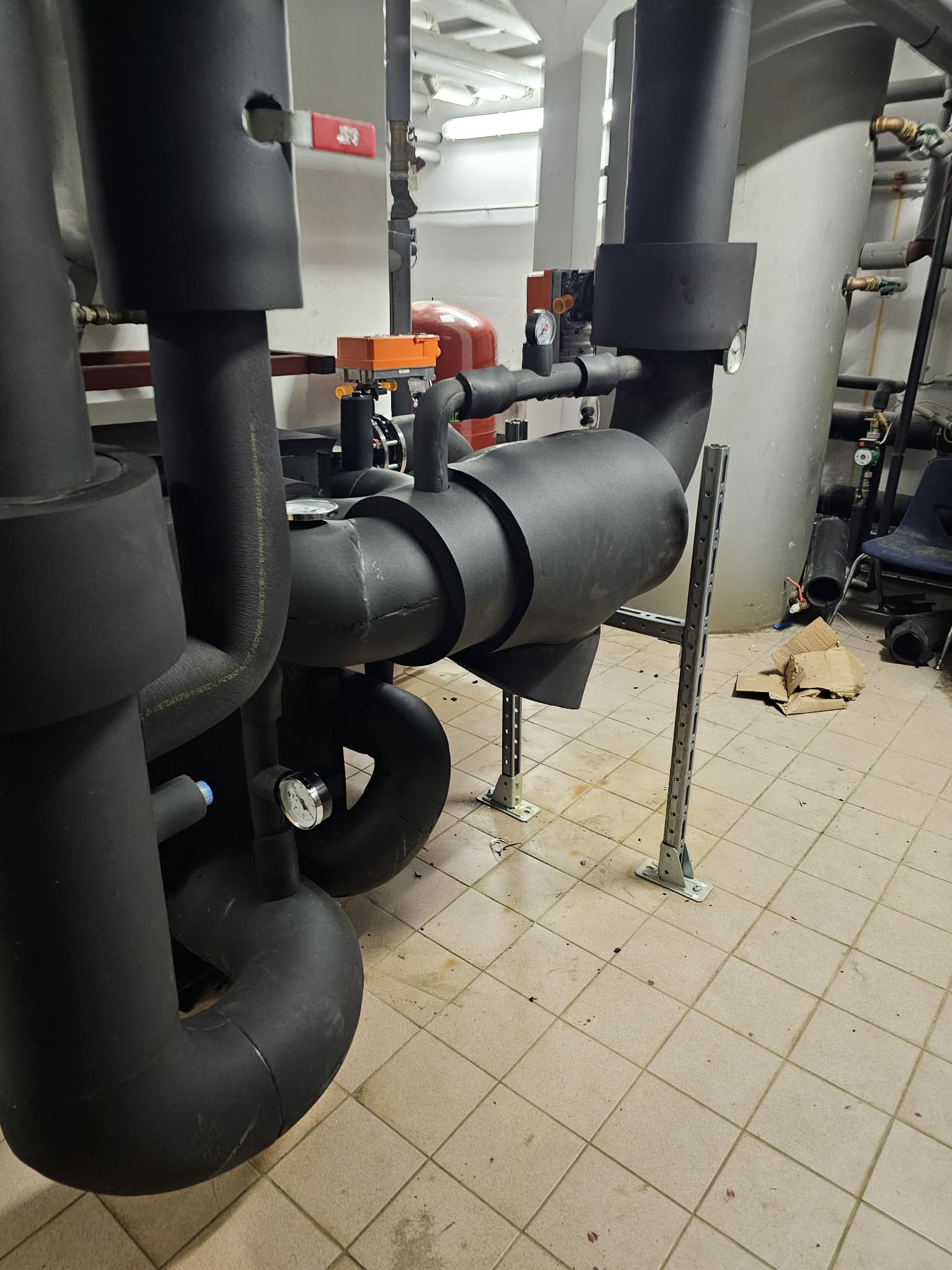 Chemical plant with specialized high-temperature insulated pipes and vessels showing industrial-grade orange insulation materials in hazardous environment